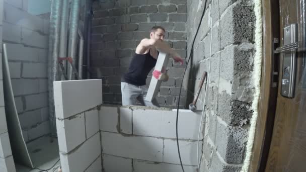 Una obra de construcción, un constructor pone una pared de bloques de gas. 4k . — Vídeos de Stock