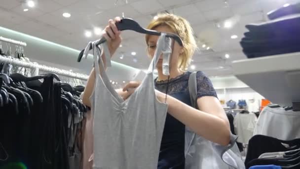 Mulher fazendo compras na loja de roupas, escolha roupas. 4k — Vídeo de Stock