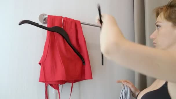 Frau im Kleiderladen einkaufen, wählen Sie Kleidung. 4k — Stockvideo