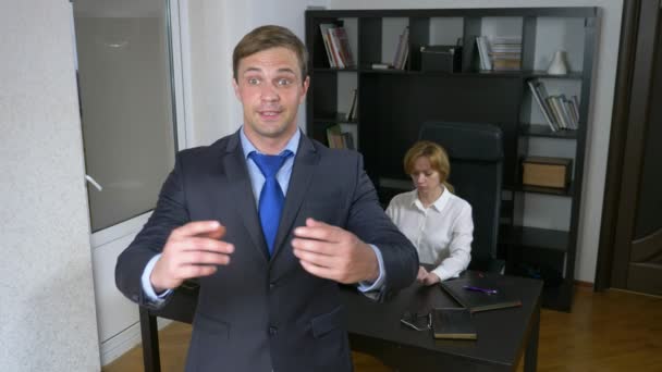 Humor, ironie. Een mannelijke manager voert een werkproces in het kantoor. 4k — Stockvideo