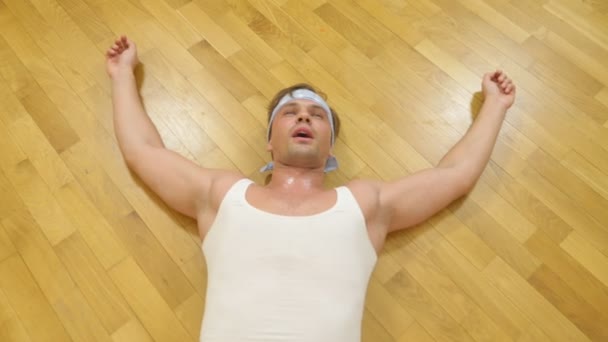 Ένας άνθρωπος κουρασμένος ενηλίκων βρίσκεται στο πάτωμα μετά από χορούς στο σπίτι, 4k — Αρχείο Βίντεο