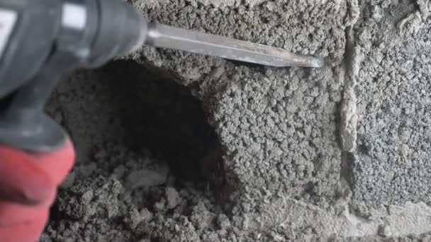 Un cantiere, un operaio che picchia il muro con un perforatore. 4k — Video Stock