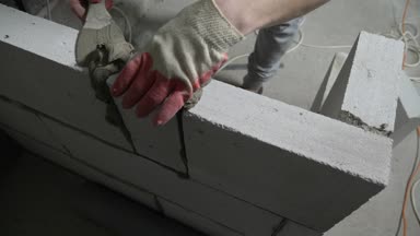 bir inşaat alanında bir Oluşturucu gaz blok duvarına koyar. 4k.