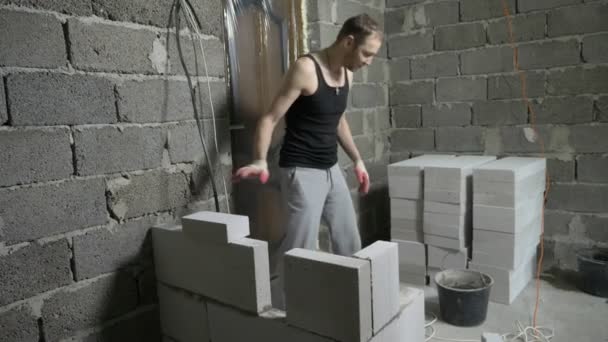 Un chantier, un constructeur met un mur de blocs de gaz. 4k . — Video