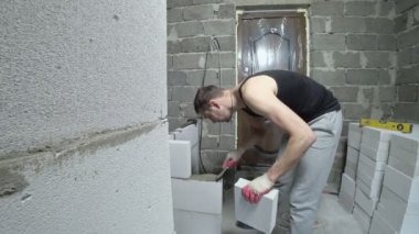 bir inşaat alanında bir Oluşturucu gaz blok duvarına koyar. 4k.