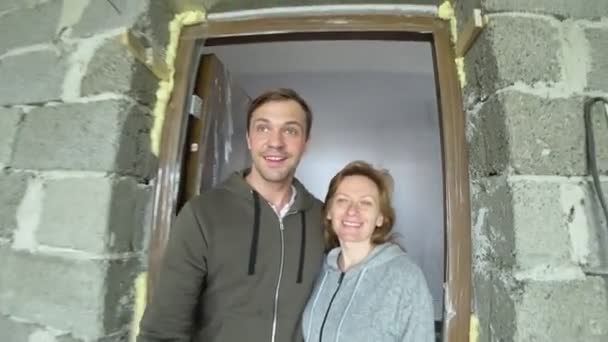 Новые поселенцы, супружеская пара приезжают в новую квартиру, оценивают ремонтные работы квартиры. они счастливы. 4k — стоковое видео