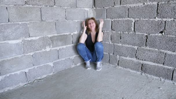 Desperat olycklig kvinna vid väggen. 4k, begreppet stress och hopplös — Stockvideo