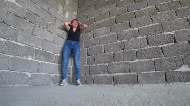 Mujer infeliz desesperada junto a la pared. 4k, el concepto de estrés y desesperación — Vídeos de Stock