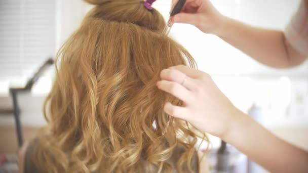 Friseur macht eine Locke für ein Mädchen, mit Haarstyling. Friseur bei der Arbeit. 4k — Stockvideo