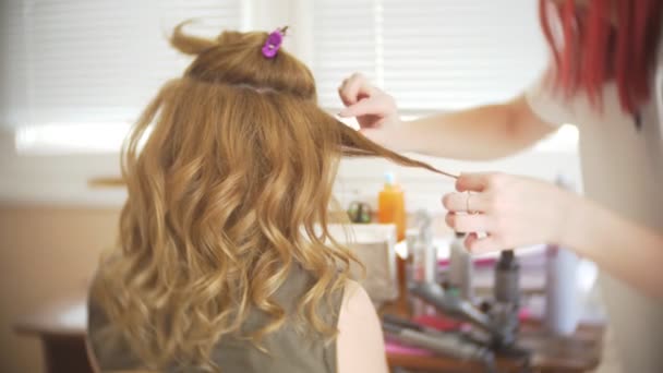 Peluquero hace un rizos para una chica, usando peinado. Peluquería en el trabajo. 4k — Vídeos de Stock