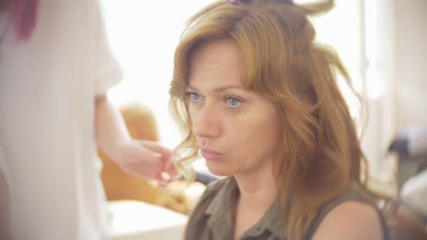 Stylista włosów sprawia, że loki dla dziewczyny, za pomocą Stylizacja włosów. Salon fryzjerski w pracy. 4k — Wideo stockowe