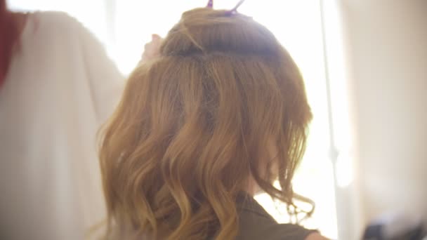 Friseur macht eine Locke für ein Mädchen, mit Haarstyling. Friseur bei der Arbeit. 4k — Stockvideo