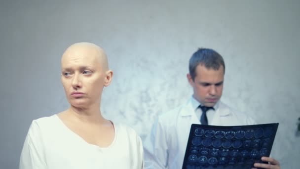 Młoda łysa kobieta u lekarza, konsultacja w sprawie wyników tomografii, złe wieści. — Wideo stockowe