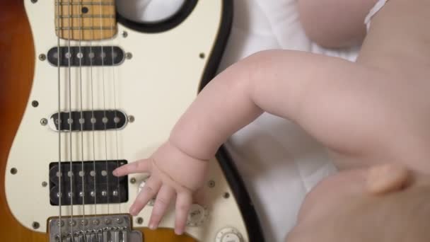 Little toddler boy playing with an electric guitar. hands closeup — Stock Video