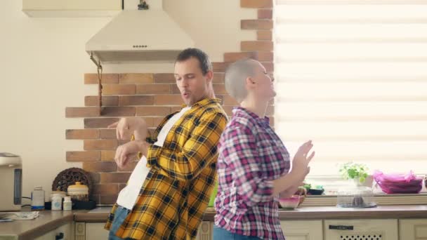 Pár férfi és kopasz nő tánc és nevetni a konyhában — Stock videók