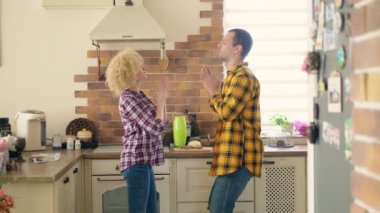 Mutfakta dans eden ve gülen çift.