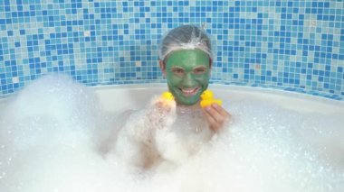 Yüzünde yeşil kozmetik maskesi olan ve duş bonesi takmış köpükle banyo yapan ve sarı oyuncak ördekle oynayan genç bir adam. Tuhaf insanların mizah anlayışı, maceraları..