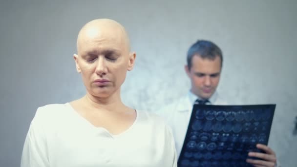Ung skallig kvinna hos läkaren, samråd om resultaten av tomografi, dåliga nyheter. — Stockvideo