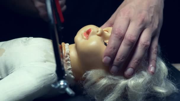 Мужские руки отпилили страшную голову куклы, Хэллоуин — стоковое видео