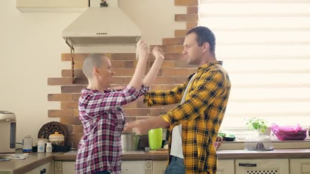 Paar man en kale vrouw dansen en lachen in de keuken — Stockvideo