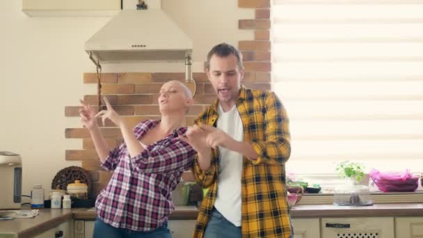 Paar man en kale vrouw dansen en lachen in de keuken — Stockvideo