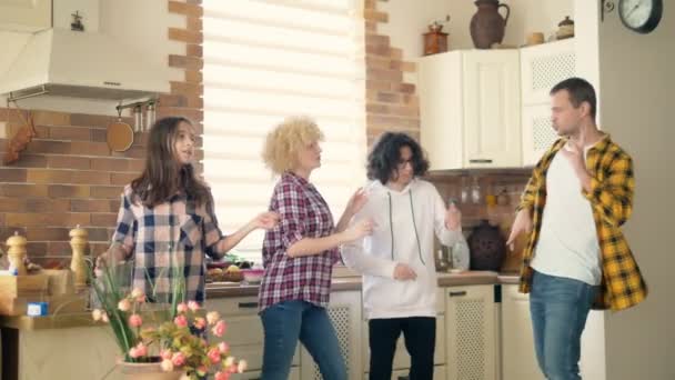 Муж, жена, мальчик и девочка близнецы подростки танцуют и смеются вместе на кухне — стоковое видео
