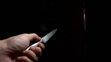 Cadılar Bayramı konsepti, şiddet. Birinci şahıs görüşü. Bıçaklı bir erkek eli karanlık bir koridor boyunca ilerliyor.