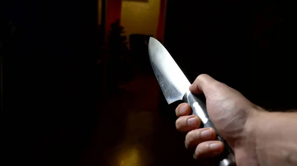 Conceito de halloween, violência. Vista em primeira pessoa. mão masculina com uma faca se move ao longo de um corredor escuro — Fotografia de Stock