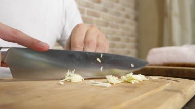 Erkek elleri tahta bir tahtada sarımsak kesiyor. yakın plan