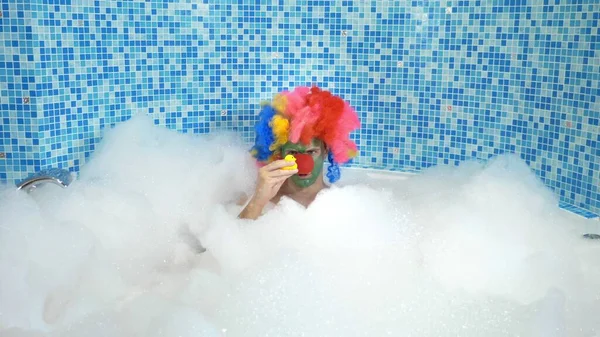 Niedlichen Clown Mann in der Badewanne mit reichlich Schaum. Humorvolles Konzept. — Stockfoto