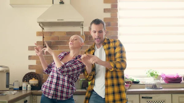 Пара чоловік і лисий жінка танцюють і сміються на кухні — стокове фото