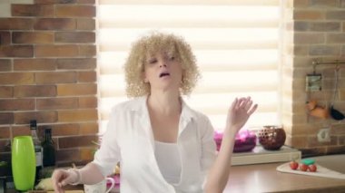 Evde dans eden seksi Brezilyalı kız işaretli pijama şortuyla saçları arkaya atıyor.