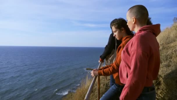 Familjesemester, livsstil koncept. Glad skallig mor, barn på en kulle med pittoresk utsikt över höga klippor och havet. — Stockvideo