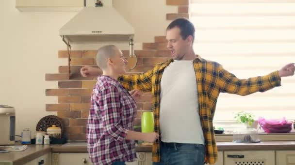 Paar man en kale vrouw dansen en lachen in de keuken — Stockvideo