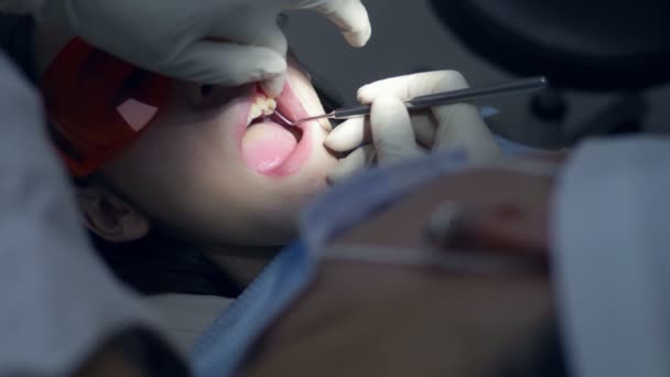 Девушка в стоматологическом кабинете. Лечение зубов. подросток — стоковое видео