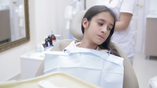 Meisje in een tandartspraktijk. Tandheelkundige behandeling. tiener — Stockvideo
