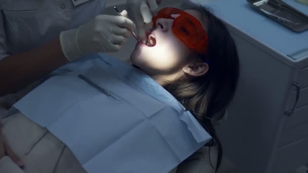 Una ragazza in uno studio dentistico. Trattamenti dentali. adolescente — Video Stock