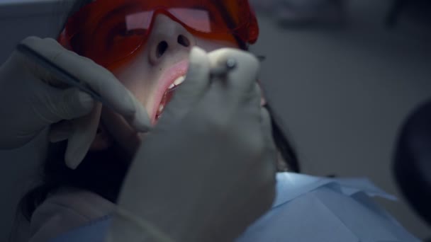 Uma rapariga num consultório dentário. Tratamento dentário. adolescente — Vídeo de Stock