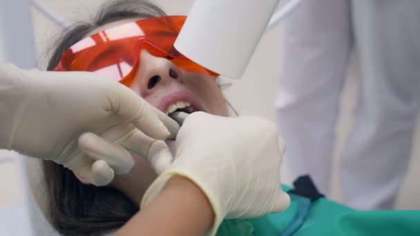 Uma rapariga num consultório dentário. Tratamento dentário. adolescente — Vídeo de Stock