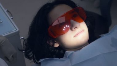 Dişçide resepsiyondaki çocuk. Ergen, önleme diş tedavisi uyguluyor