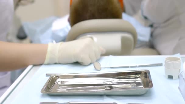 Closeup. the woman visit the dentist. hands of dentist with gloves on — Stock Video