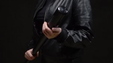 Yakın plan. Siyah arka planda beyzbol sopası tutan kadın elleri.