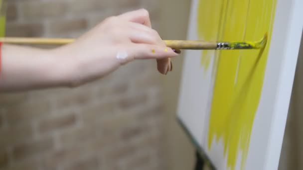 Primer plano. pintura de mano femenina con un pincel sobre lienzo con pinturas al óleo — Vídeos de Stock