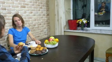 İki kız lezbiyen mutfakta oturmuş çay içiyor.