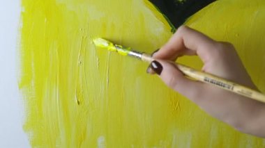 Yakın plan. ... yağlı boyalarla tuvale fırçayla resim çizen kadın el resmi.