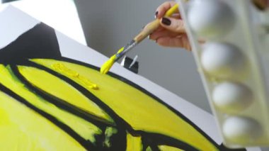 Yakın plan. ... yağlı boyalarla tuvale fırçayla resim çizen kadın el resmi.