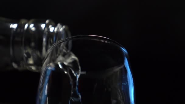 Крупный план. прозрачный алкогольный напиток наливают из бутылки в стакан — стоковое видео