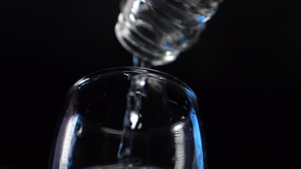 Yakın plan. Şeffaf alkollü içecek şişeden bardağa dökülür. — Stok video
