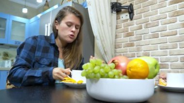 İki kız lezbiyen mutfakta oturmuş çay içiyor.