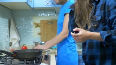 İki kız, lezbiyen aile evdeki mutfakta yemek hazırlıyorlar.